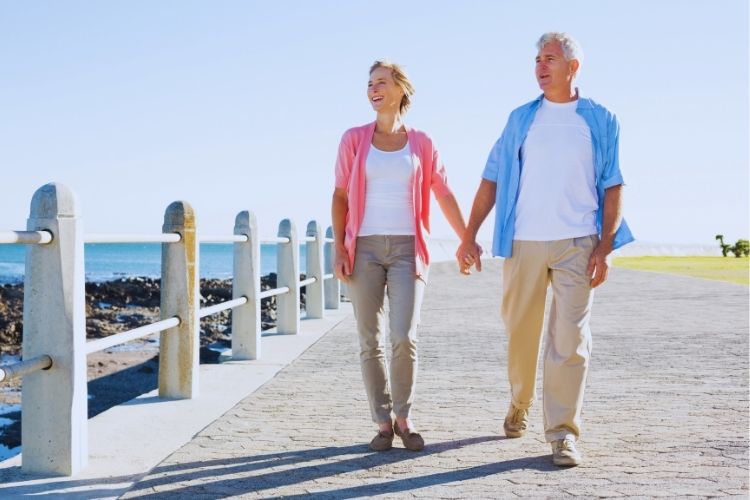 Financial Adviser Gold Coast - Adult couple strolling by beachfront road