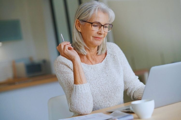 Financial Adviser Gold Coast - Elderly woman writing details on her laptop